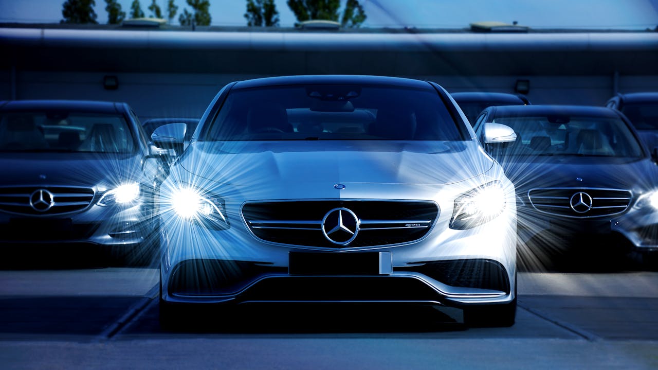 The Art of Drawing Readers In: Your attractive post title goes here Front view of a lineup of Mercedes-Benz cars with bright headlights, showcasing luxury and elegance.