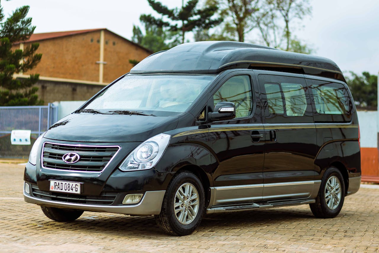 A black Hyundai van parked outdoors in a lot on a clear day.