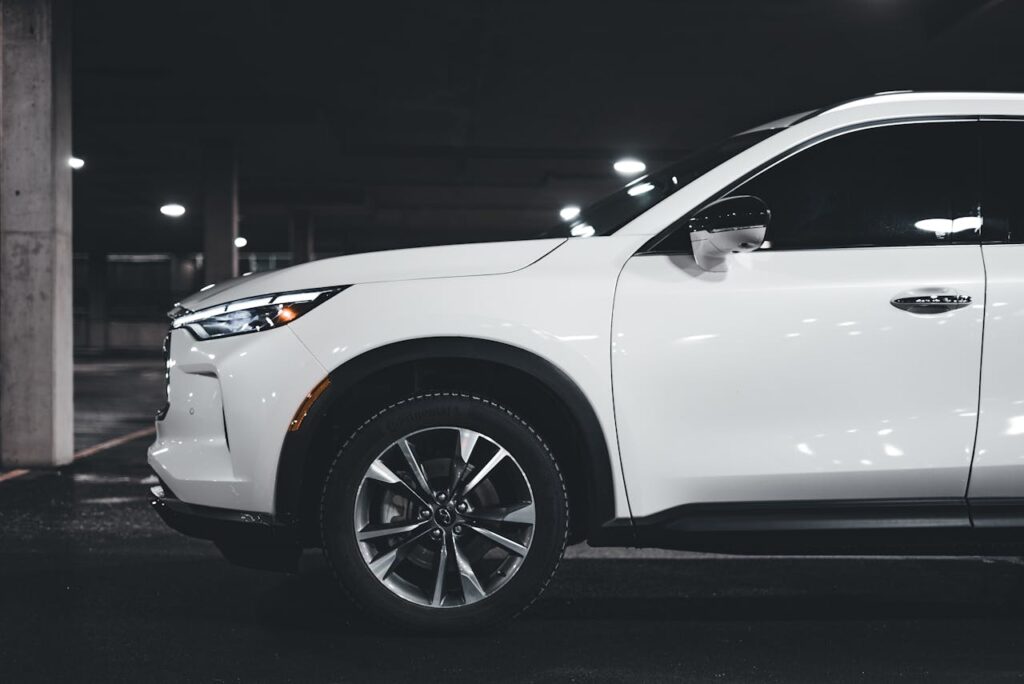 pexels photo 19410440 A stylish white SUV parked in an urban garage showcasing modern luxury design elements.